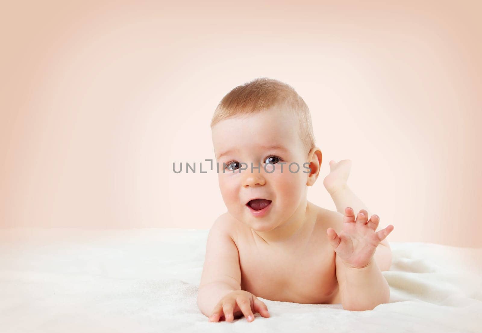 cute eight month old baby lying on soft blanket at home