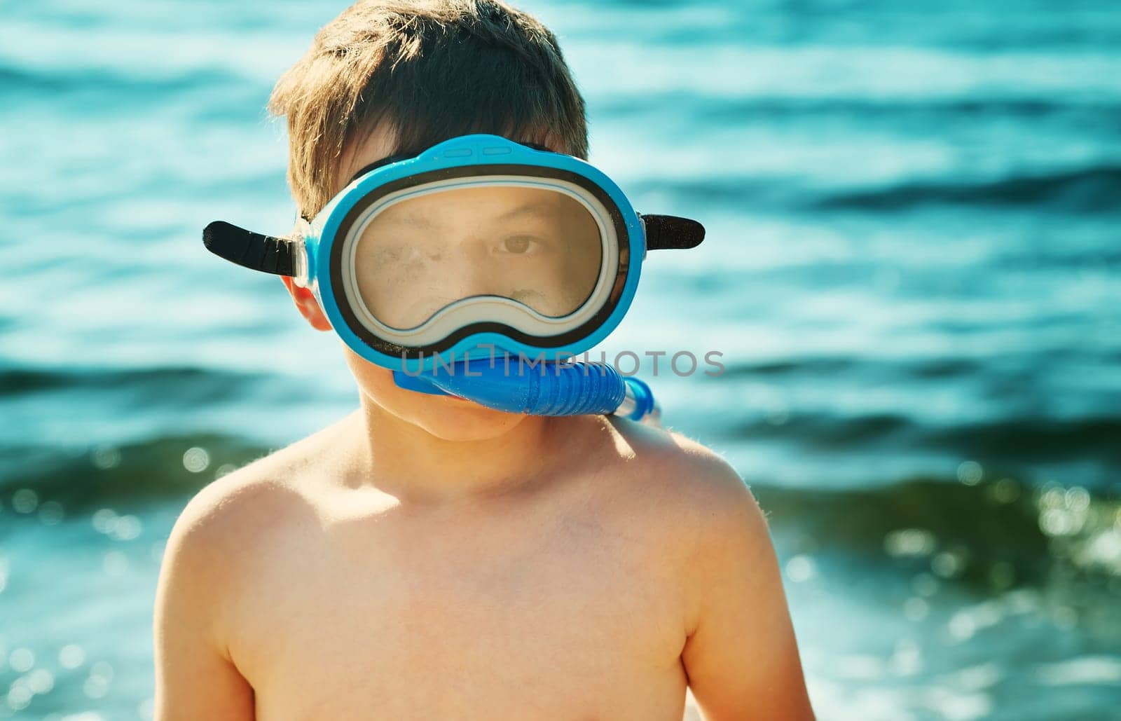 Child on the beach with swimming mask. Boy on vacation at sea