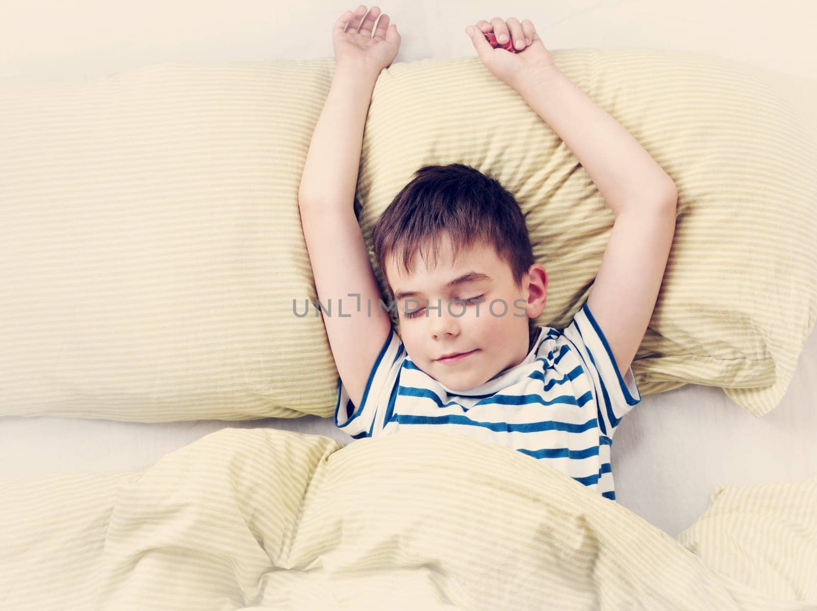 seven years old child lying in the bed with green bedding