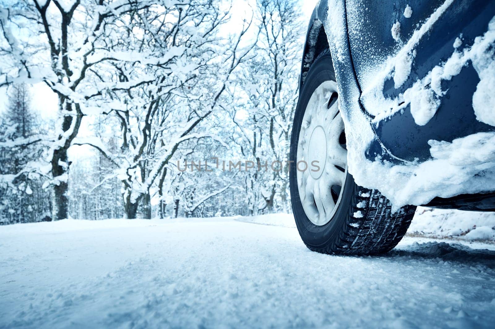 Car tires on winter road covered with snow