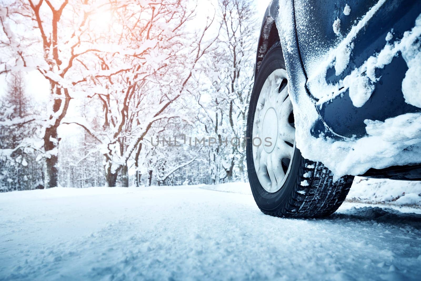 Car tires on winter road covered with snow