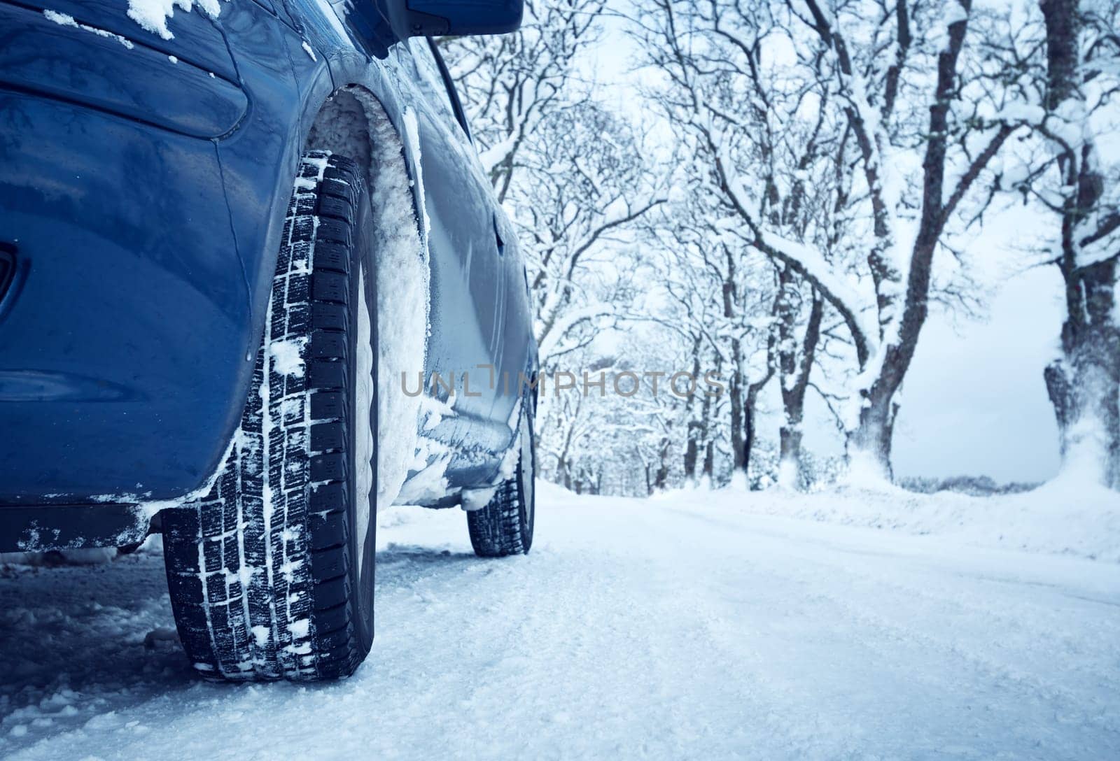 Car tires on winter road covered with snow