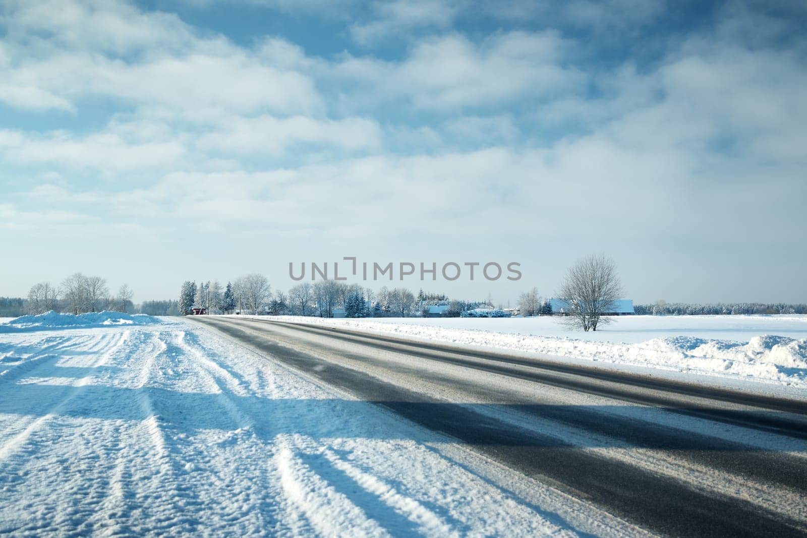 Asphalt road in snowy winter on beautiful frosty sunny day