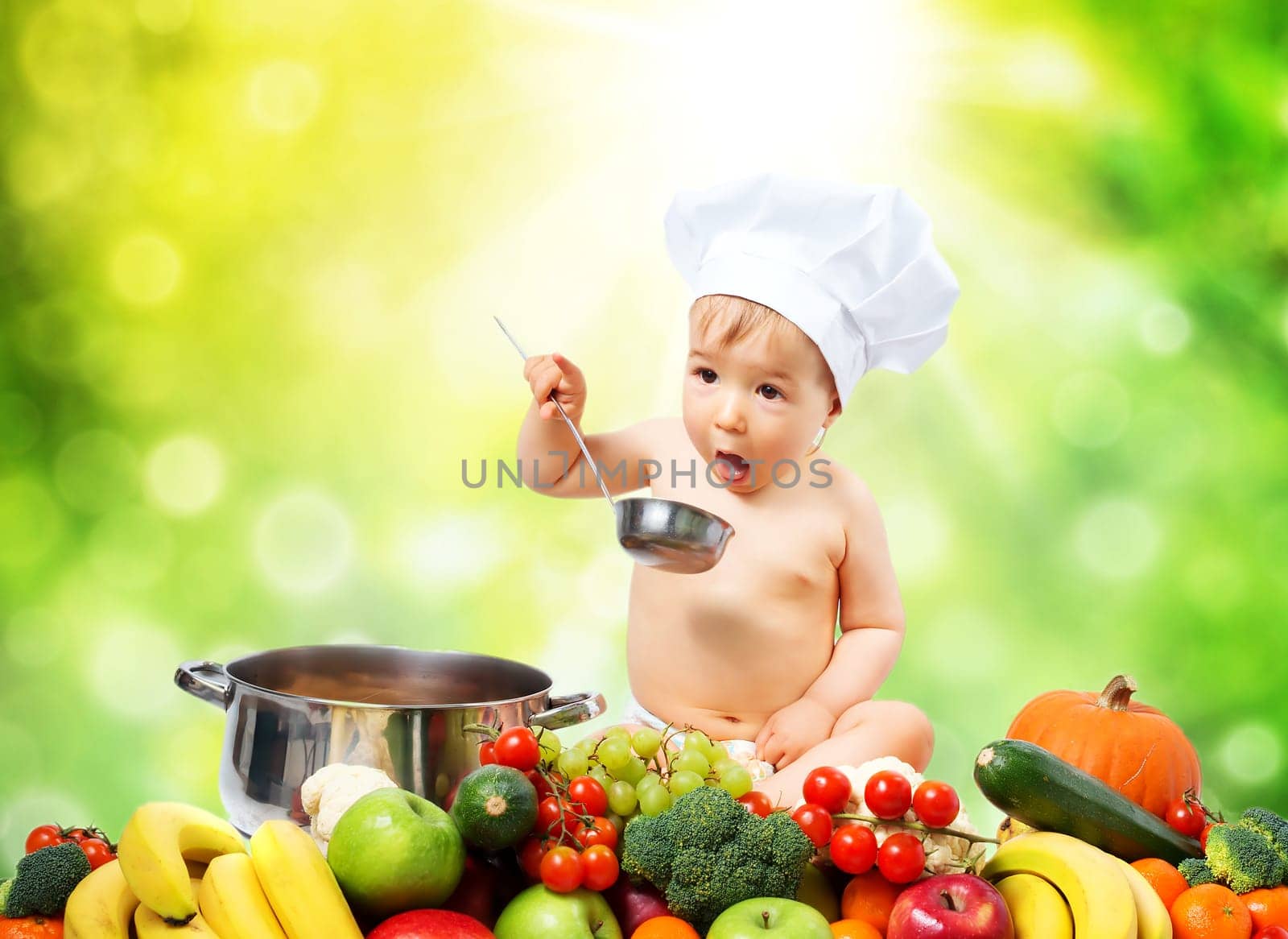Baby boy in chef hat sitting with cooking pan and raw vegetables