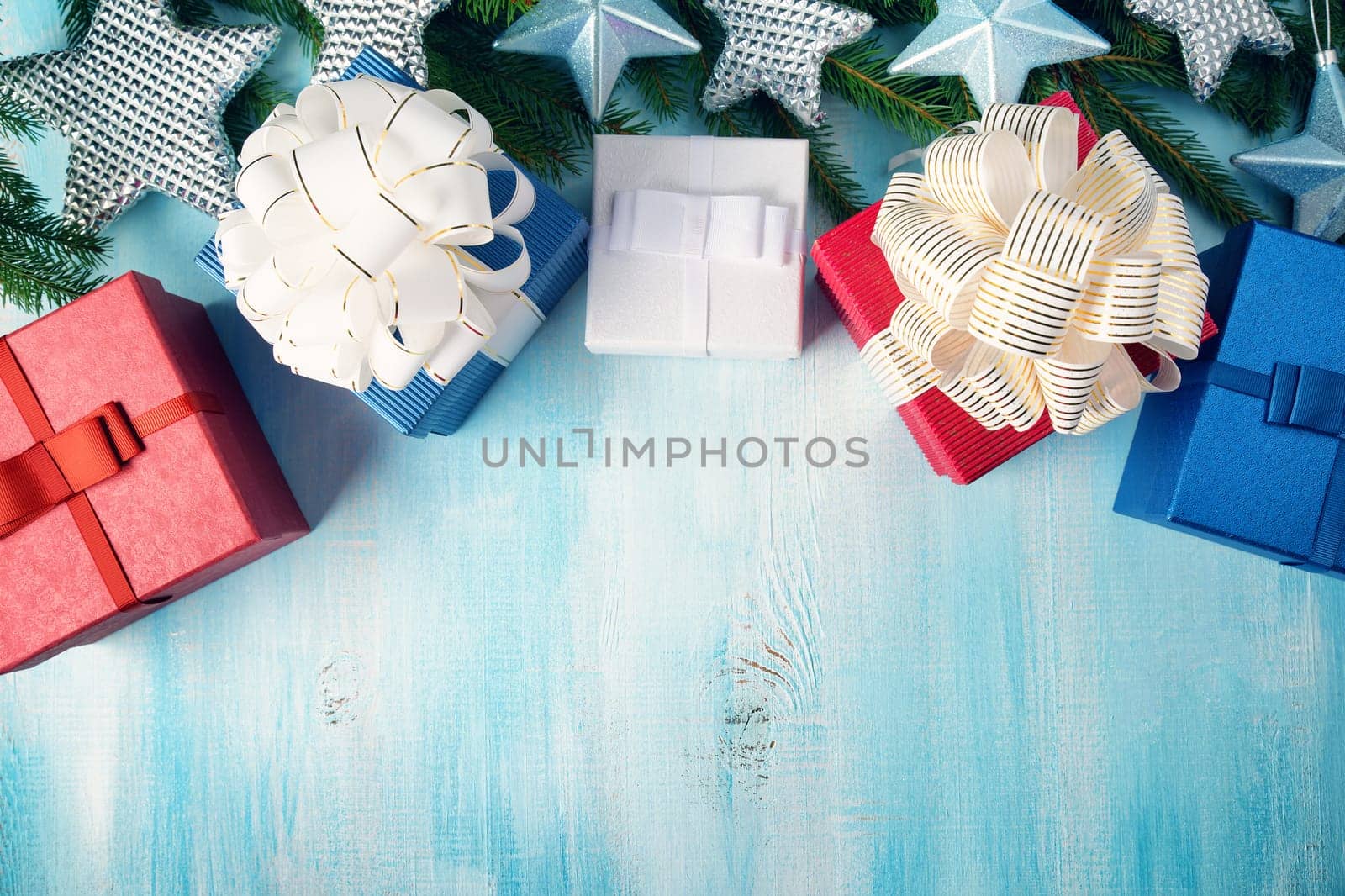 Christmas stars on wooden background with fir tree branches. Winter background with presents