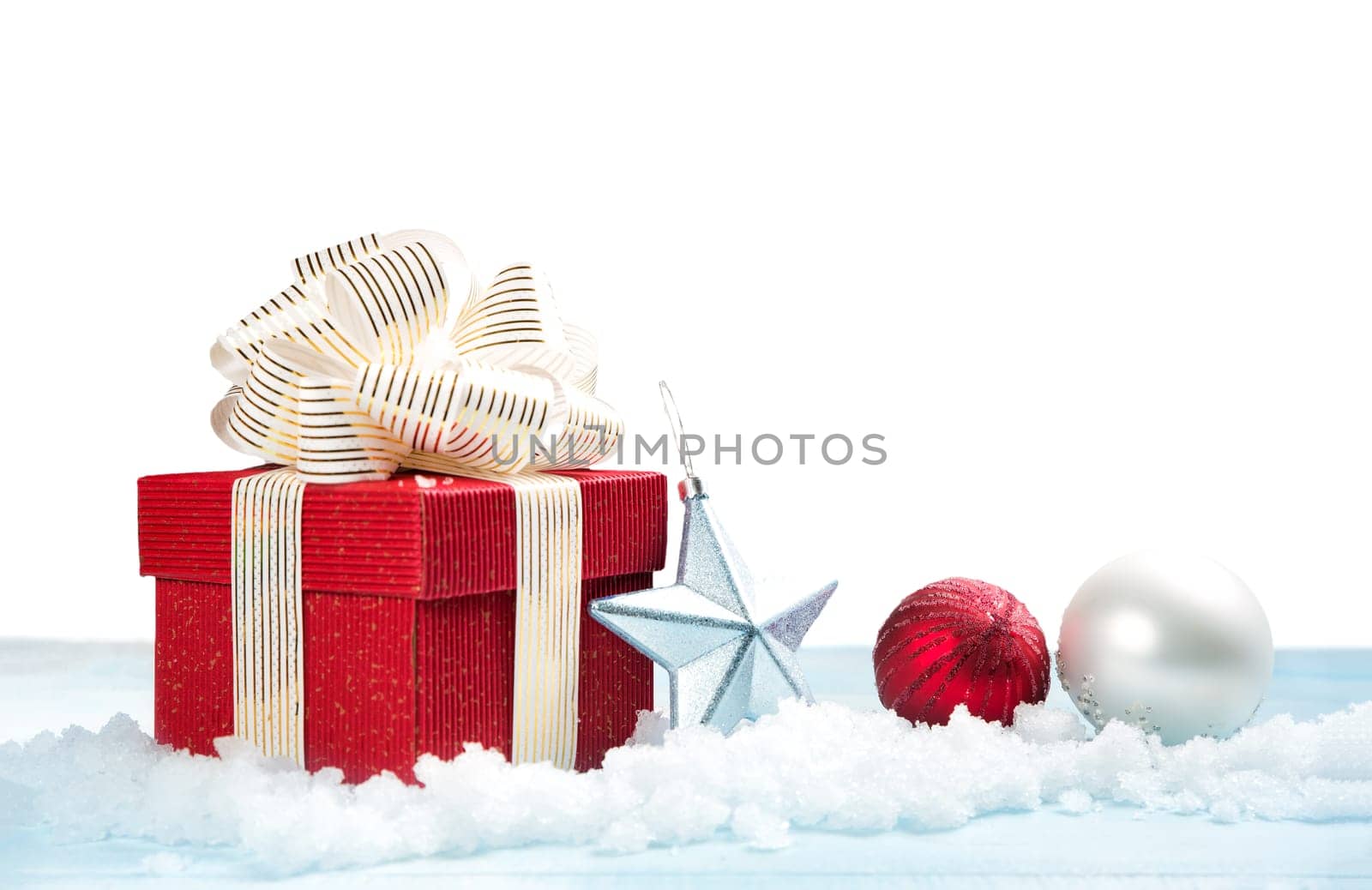 Red gift box on snow on white background