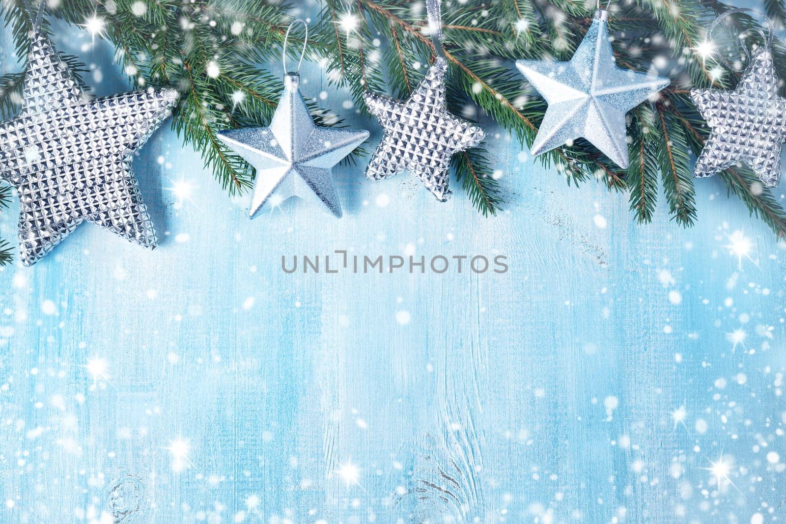 Christmas stars on wooden background with fir tree branches. Winter background