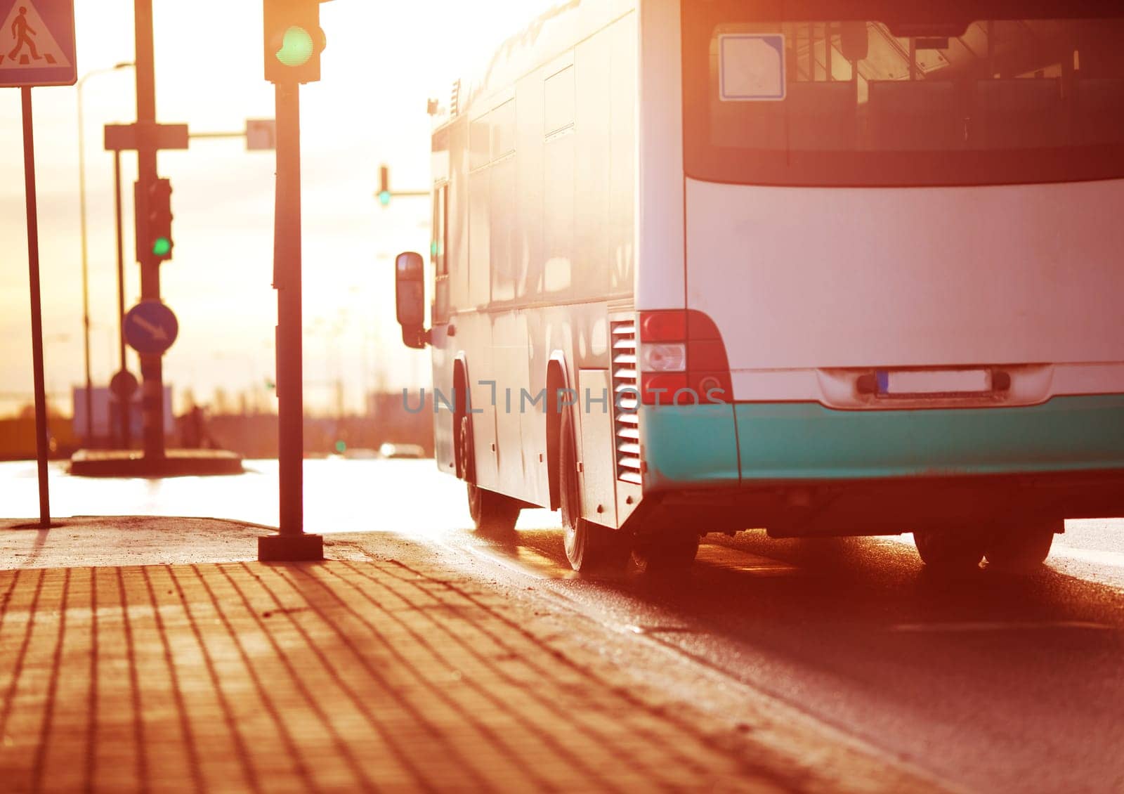 Bus moving on the road in city in early morning. View to the traffic with trafficlights and transport