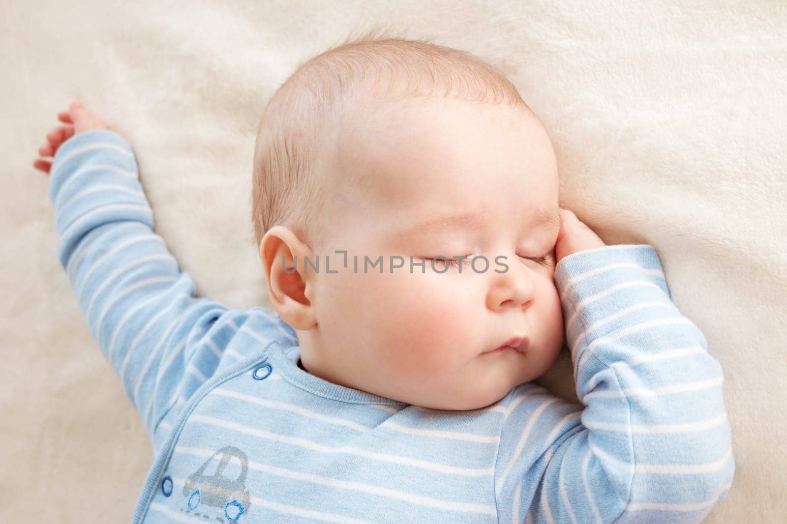 little boy sleeping on soft white blanket