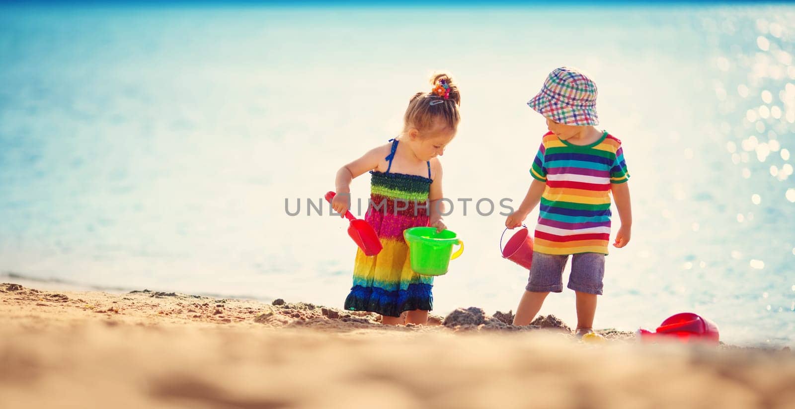 Boy and girl playing on the beach on summer holidays
