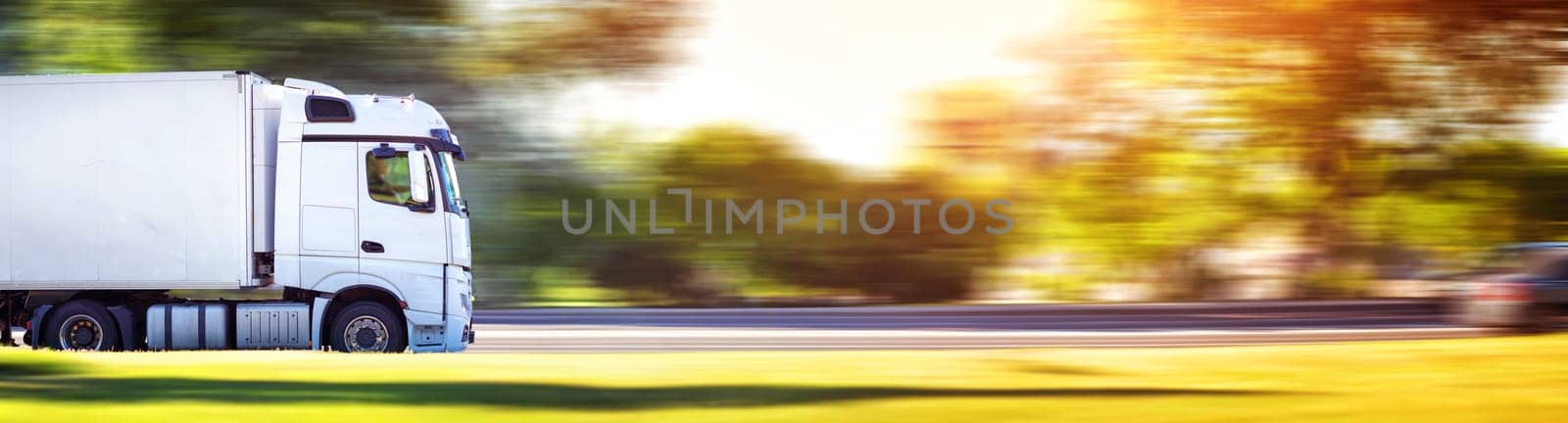 asphalt roadwith a tilt truck. lorry moving on sunny evening