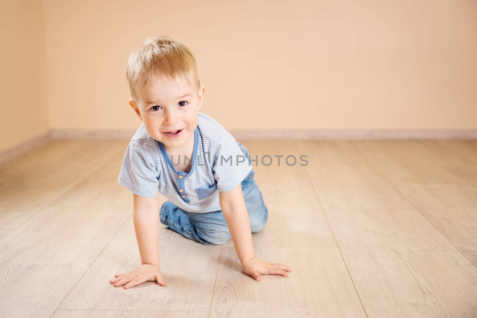 Portrait of a two years old child lying on the floor. Pretty little boy at home