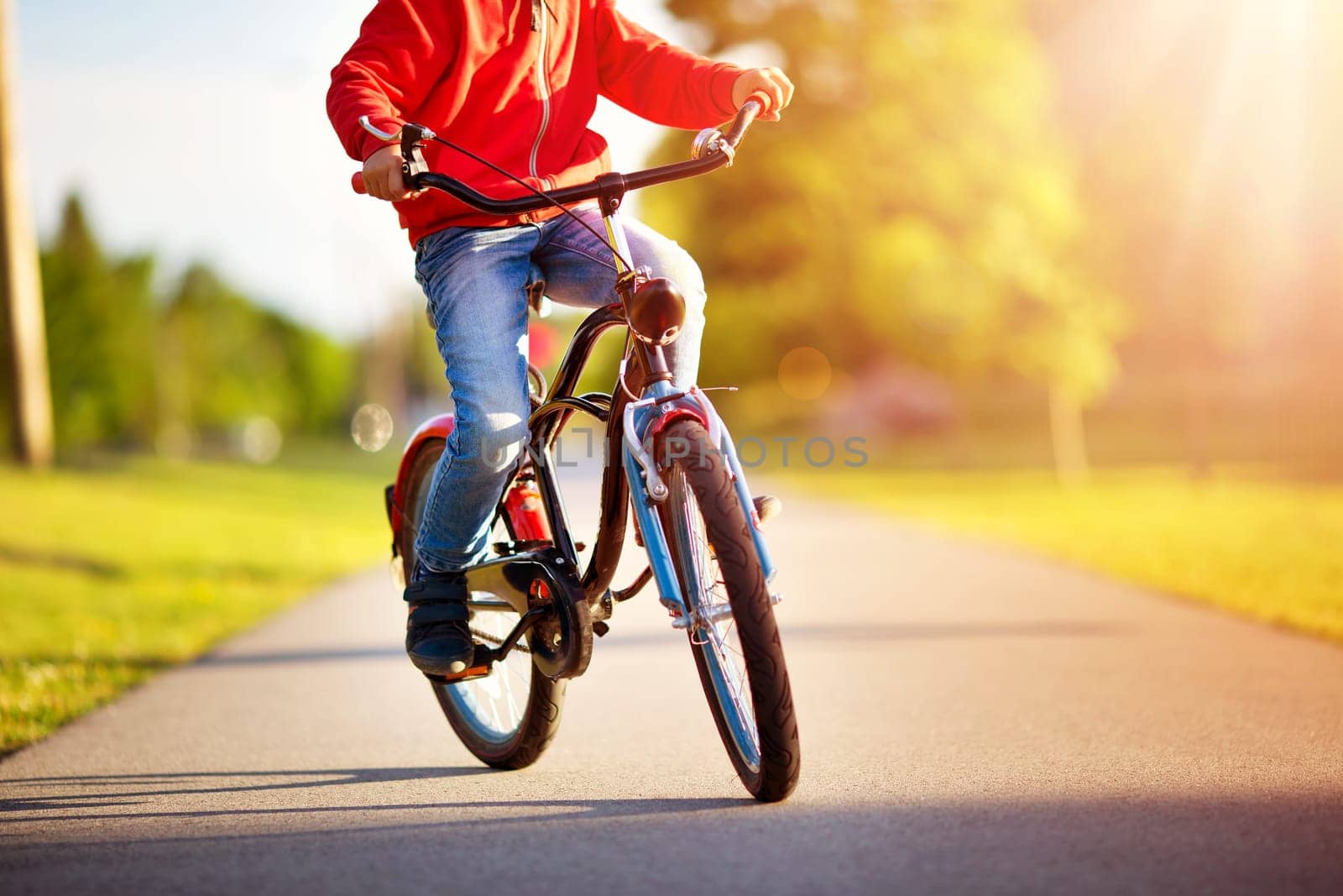 child on a bicycle at asphalt road in early morning