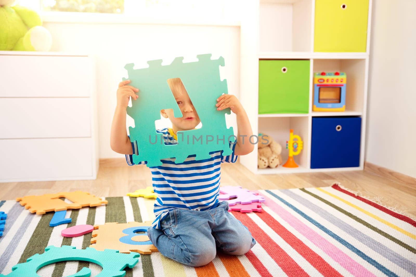 Little child playing with numbers. Boy sitting on the floor at home