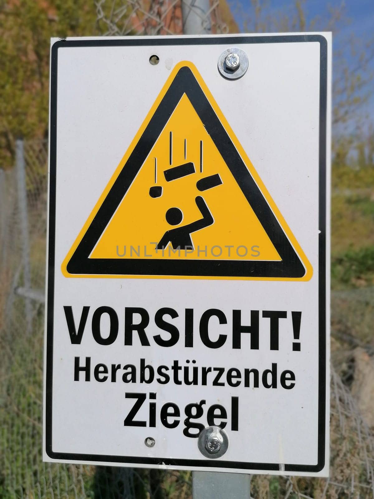 Sign with the inscription "Caution falling roof tiles"" on a ruin in the port of Magdeburg in Germany"