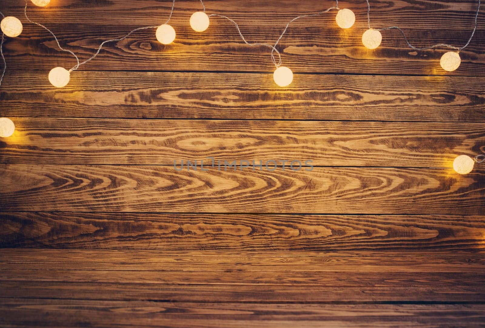 Old wooden planks with christmas decoration. Brown background with lightbulbs
