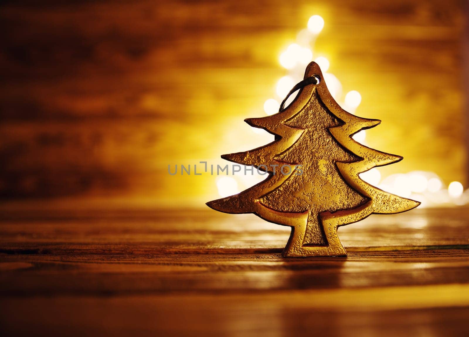 Fir tree toy on wooden background with christmas lights.