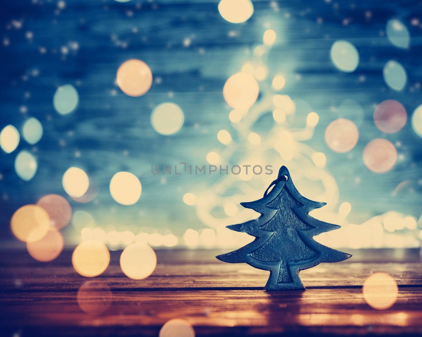 Fir tree toy on wooden background with christmas lights.