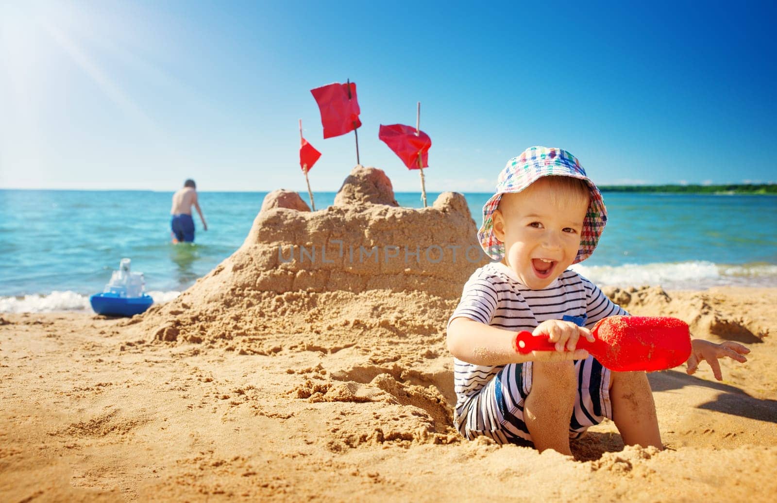 boy sitting smiling at the beach. Child on vacations at sea