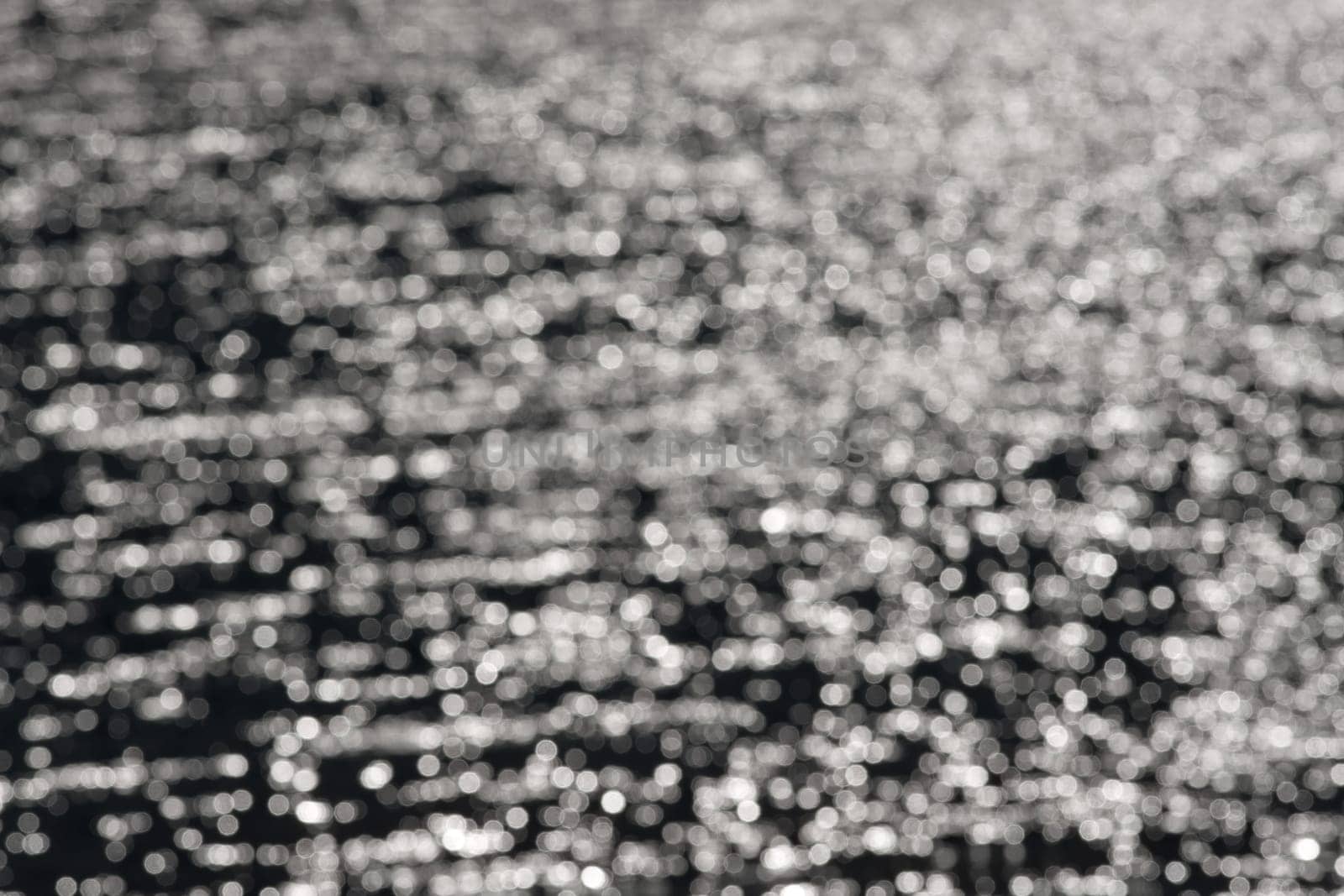 3 - Graduated light to dark bokeh, formed from water ripples and sunlight, giving an abstract textured monochrome background, black and white.