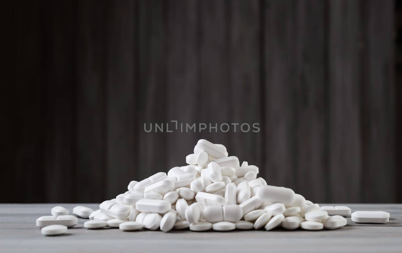 Pills spilled on gray background. A lot of white tablets