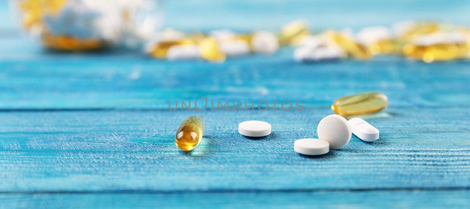 Pills in a jar on wooden background. Drugs in a bottle