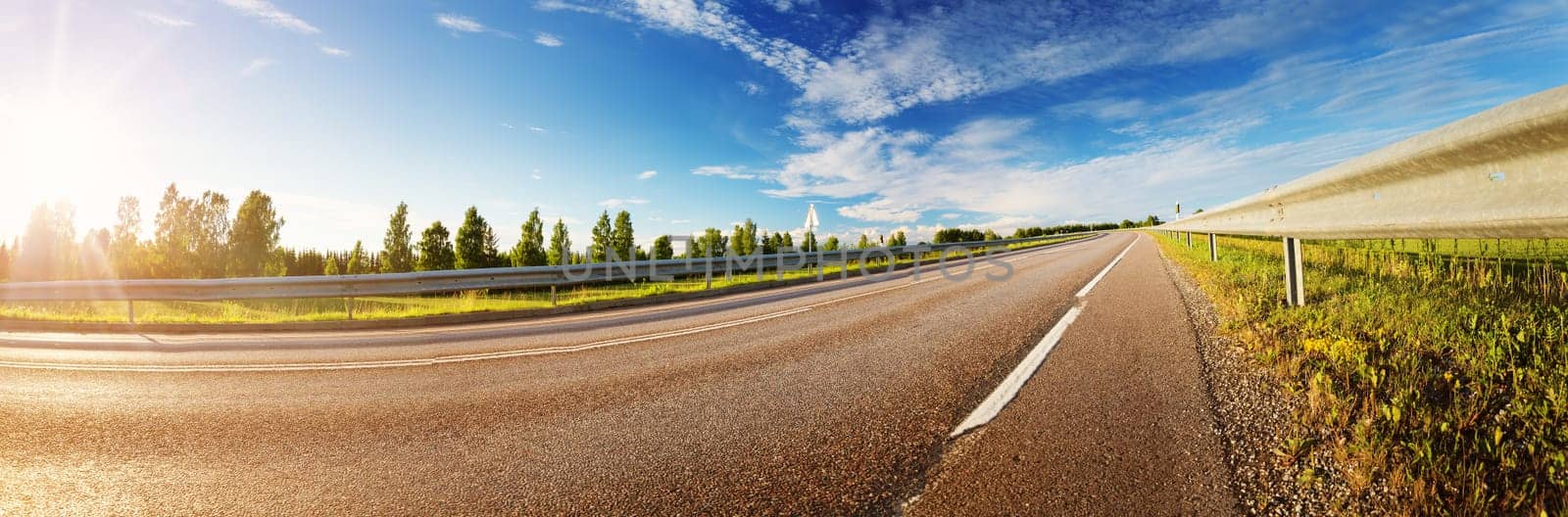 asphalt road panorama in countryside on sunny summer day. Empty highway landscape outdoors in nature with green grass and blue sky