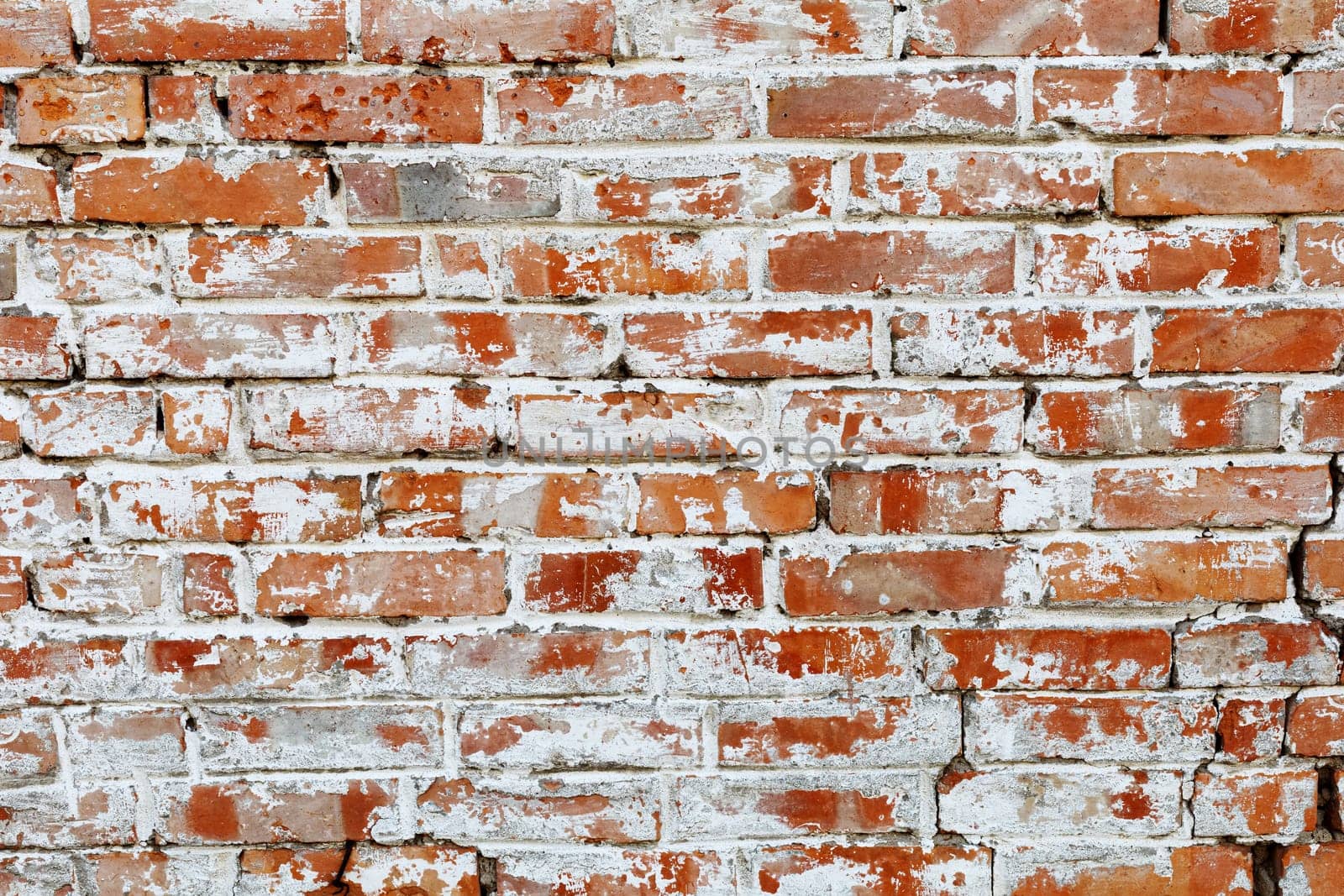 Rustic red brick background with white paint. Dirty wall pattern of an old building. Brickwall texture