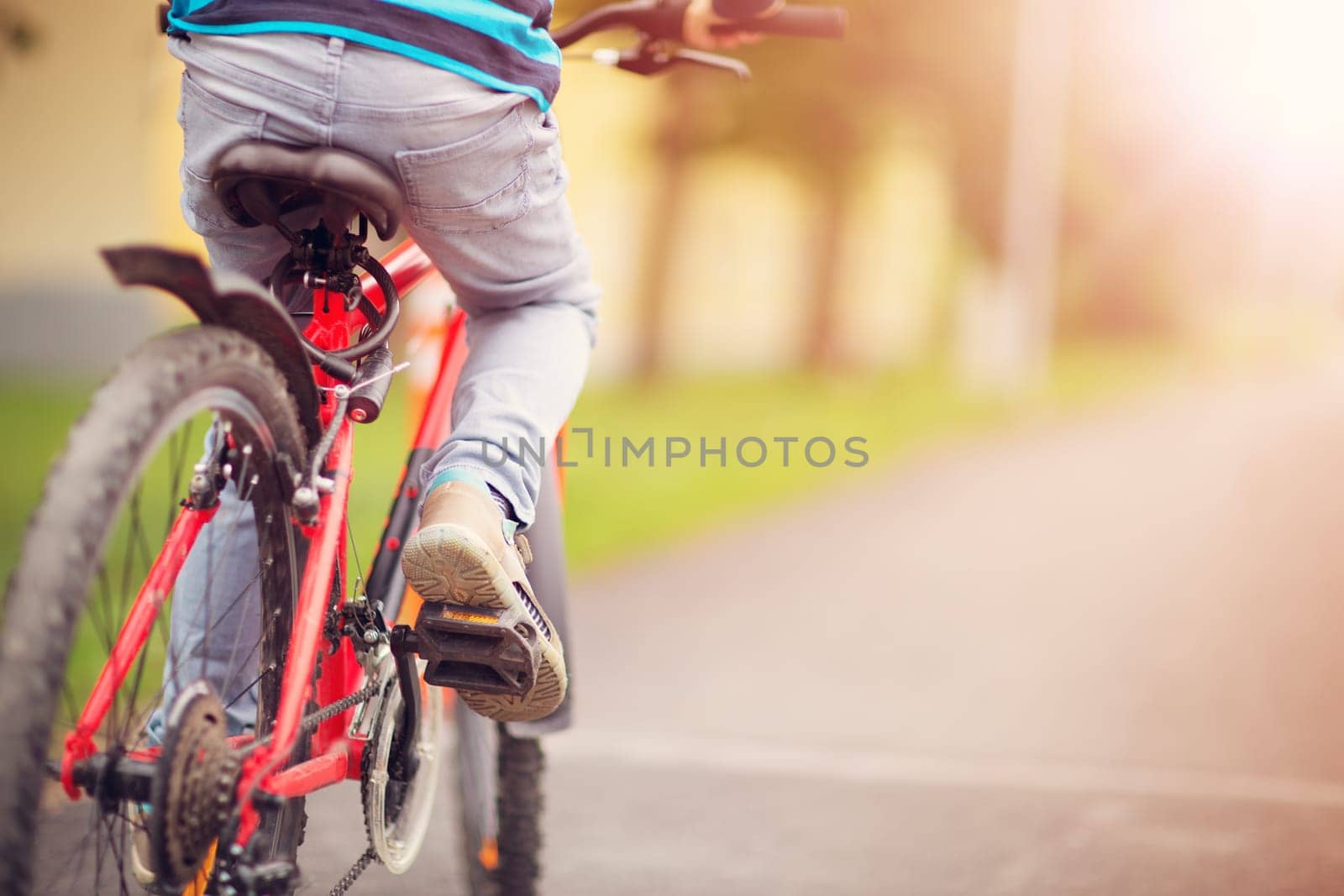 child on a bicycle at asphalt road in early morning. Boy on bike in the city
