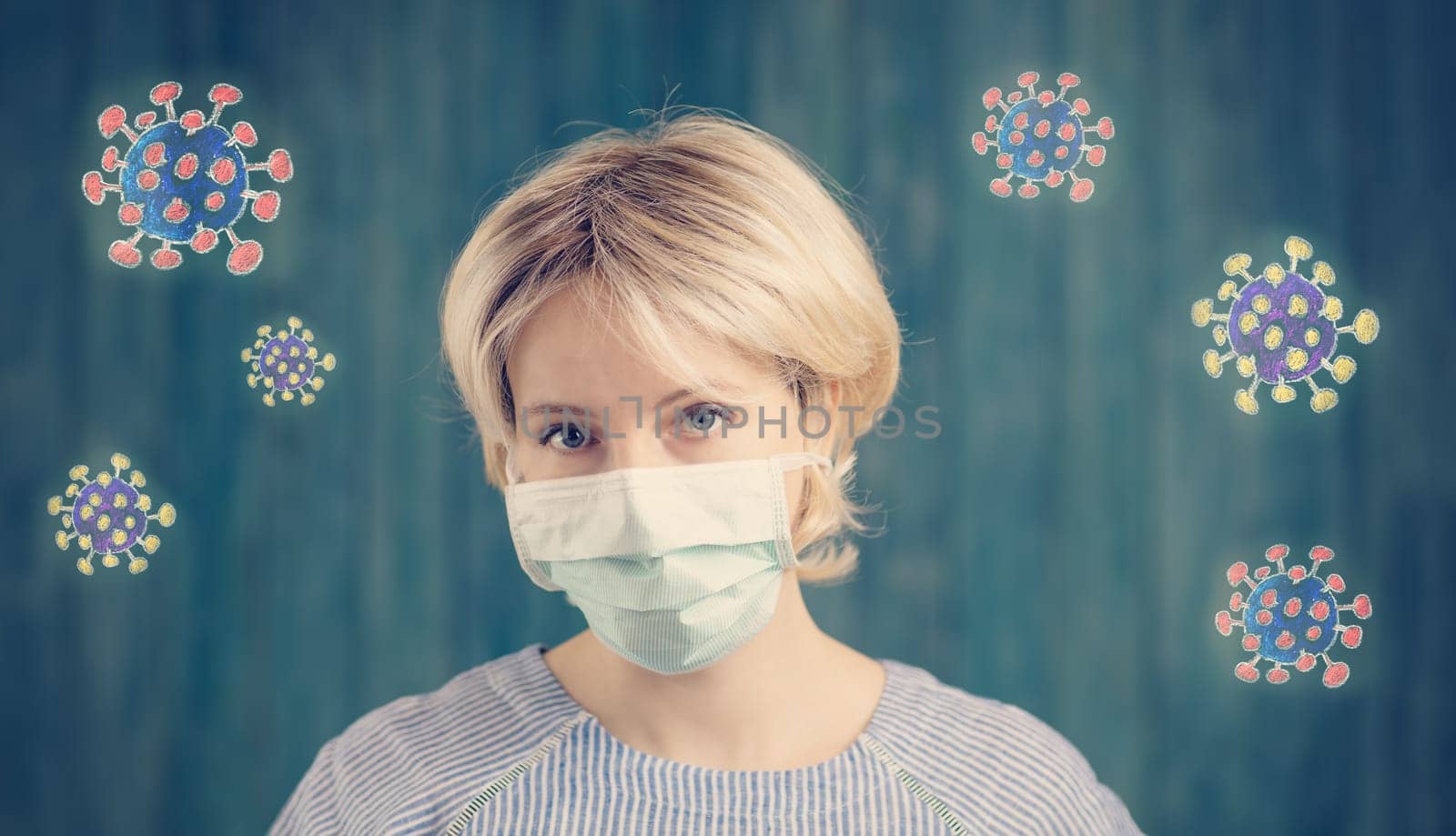 young woman in medical face protection mask indoors on blue background. Sick person