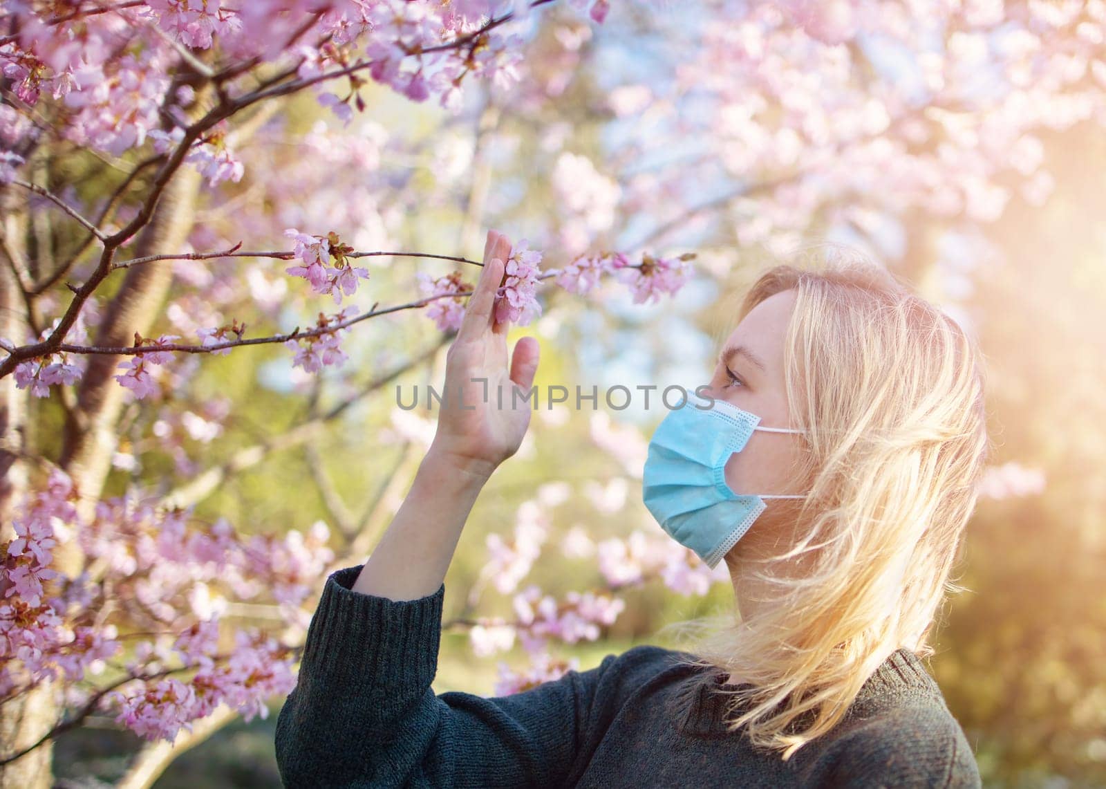 young woman in medical face protection mask outdoors in nature. Sick person