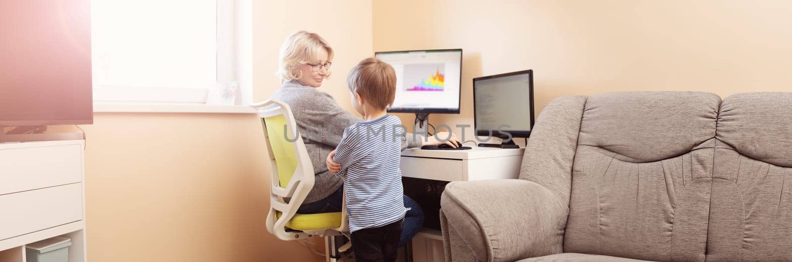 woman working at home with little child. Young businesswoman working indoors at pc