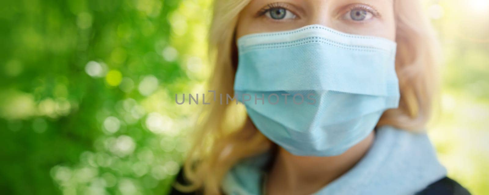 young woman in medical face protection mask outdoors in nature. Sick person