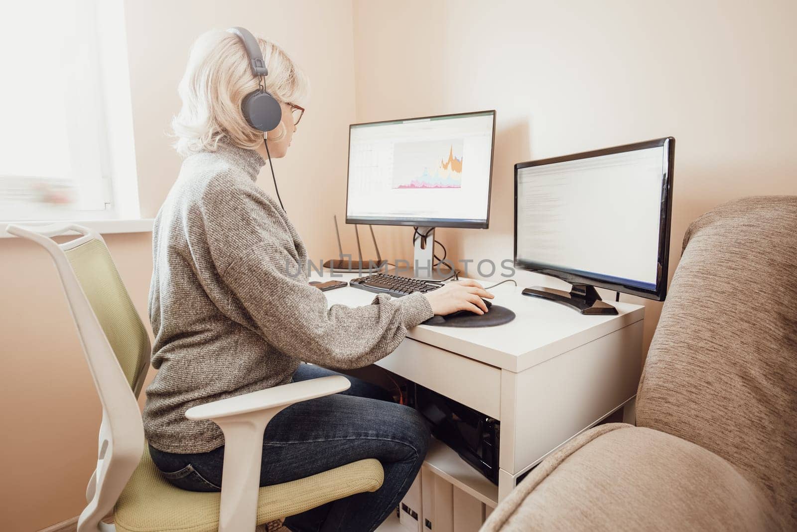 woman working at home in homeoffice. Young businesswoman sitting indoors and using pc