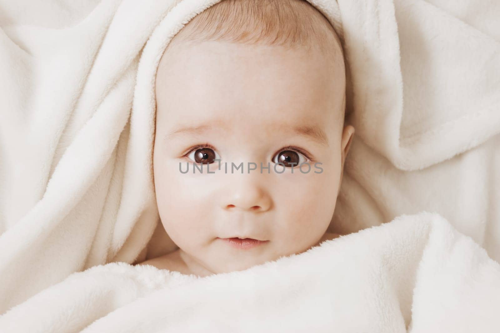 little boy sleeping on soft white blanket