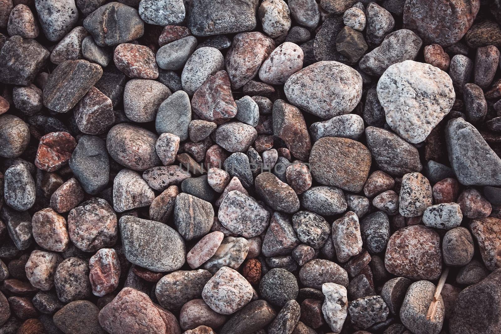 texture with multicolored stones on rocky beach in summer