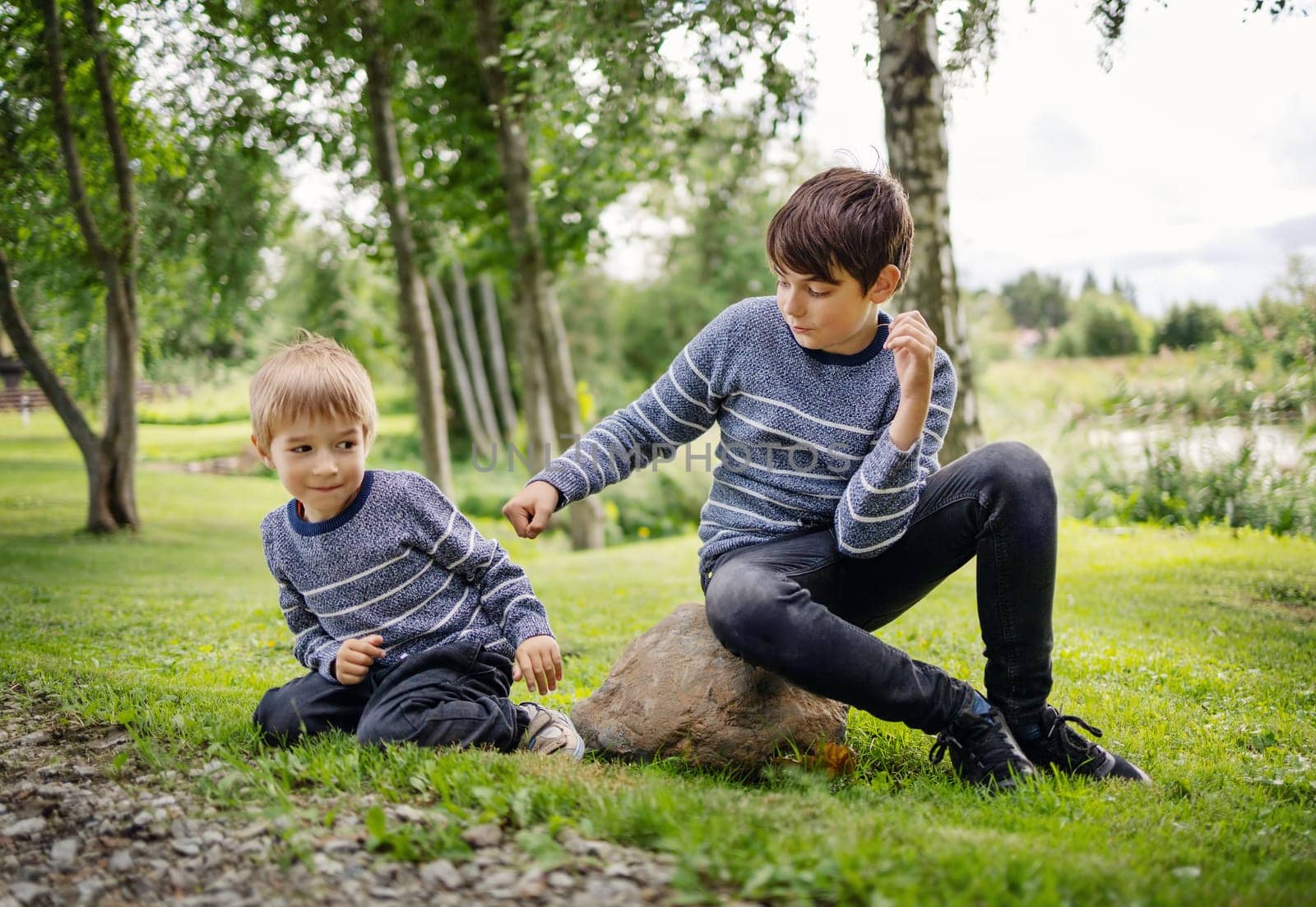 Two brothers fighting in park. Boys bullying
