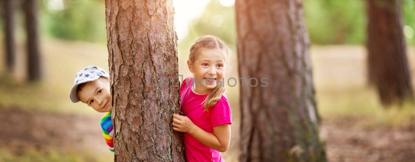Boy and girl walking on the field in summer. Children outdoors