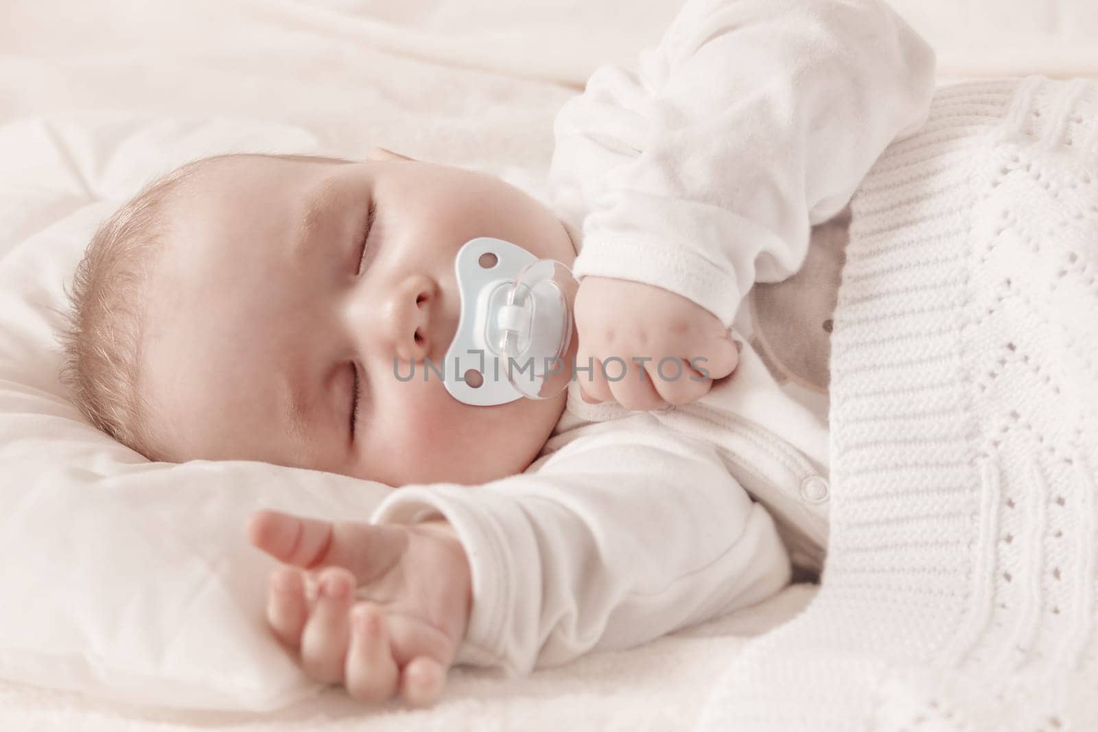 little boy sleeping on soft white blanket. 7 month old baby asleep
