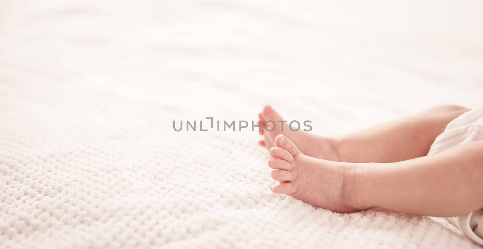 Cute newborn baby girl lying in the bed. Two weeks old infant child on white soft blanket