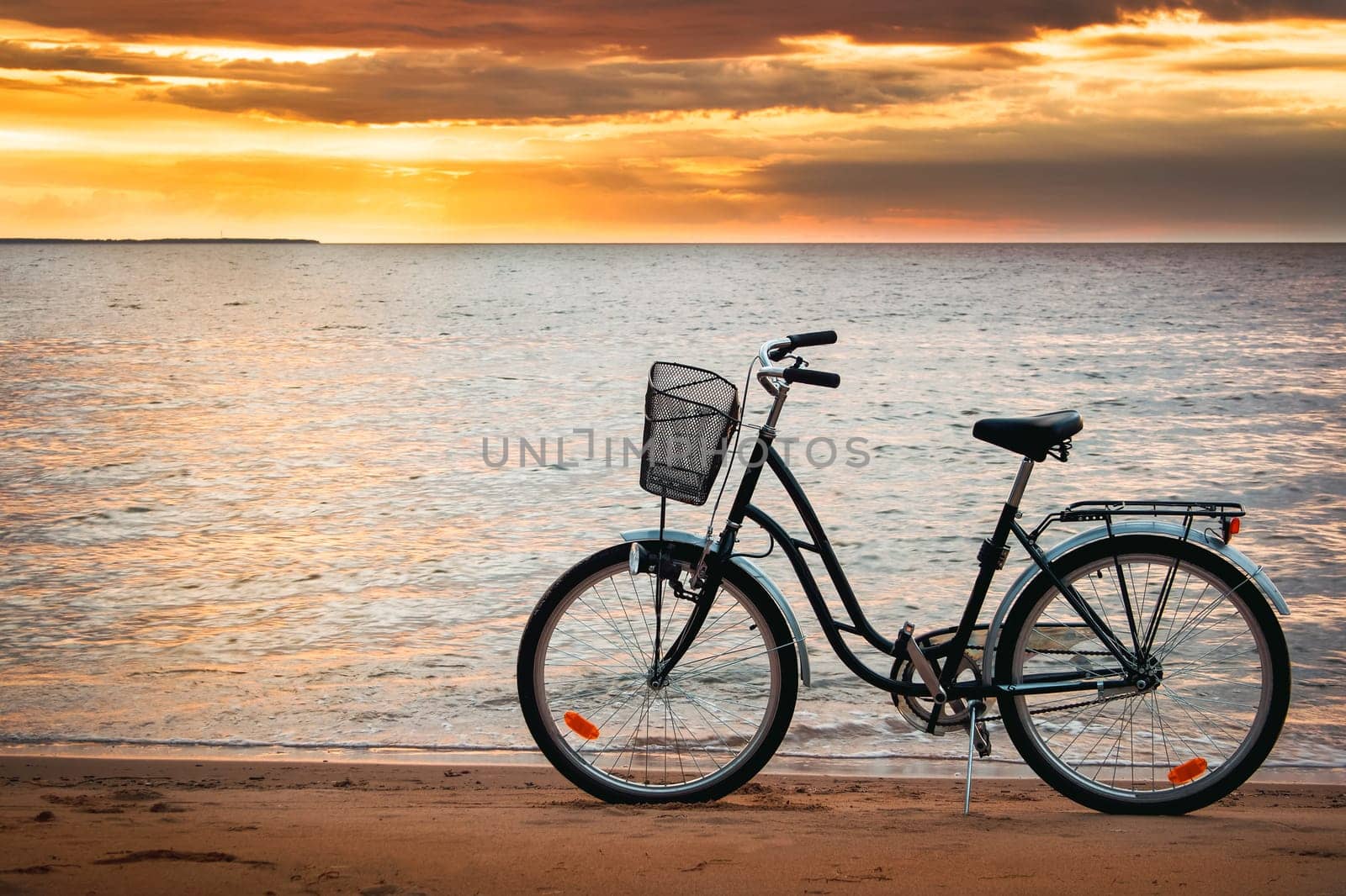 Lonely bike standing at sunset at seaside in summer