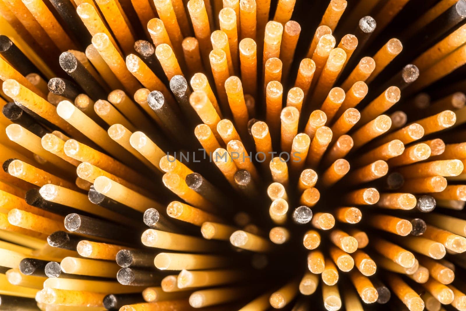 A close up view of the ends of three different types of spaghetti standing upright.
