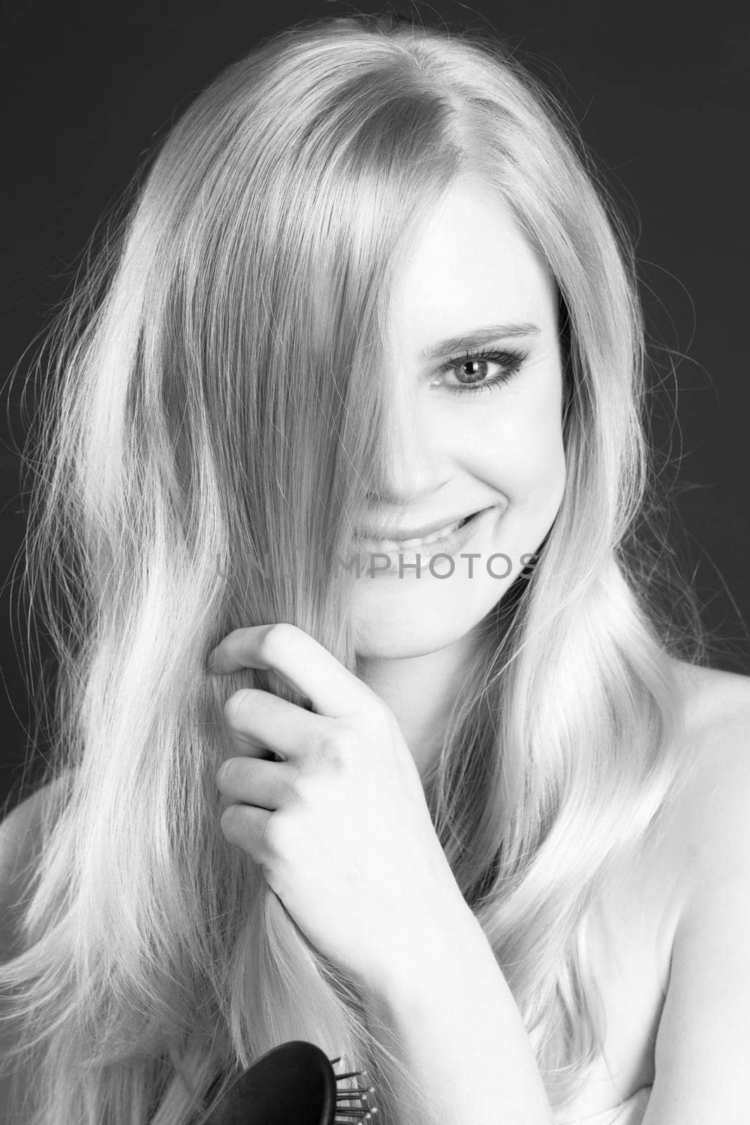Woman has fun smiling laughing while brushing out her hair