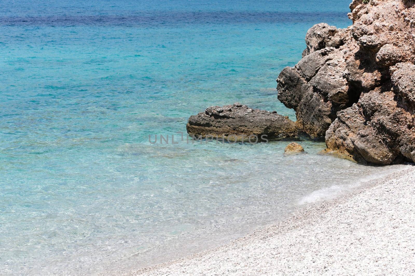 Clear turquoise water rocky beach of Porto Germeno, Attica, Greece