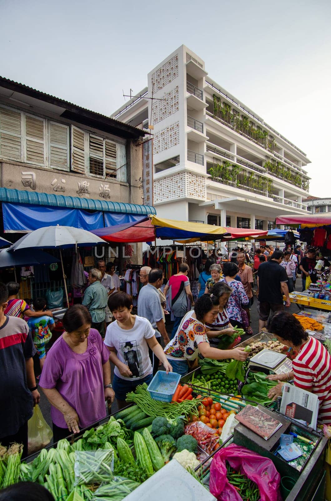 Georgetown, Penang/Malaysia - Aug 07 2016: People but vegetables at morning market. Background is Chowrasta bazaar.