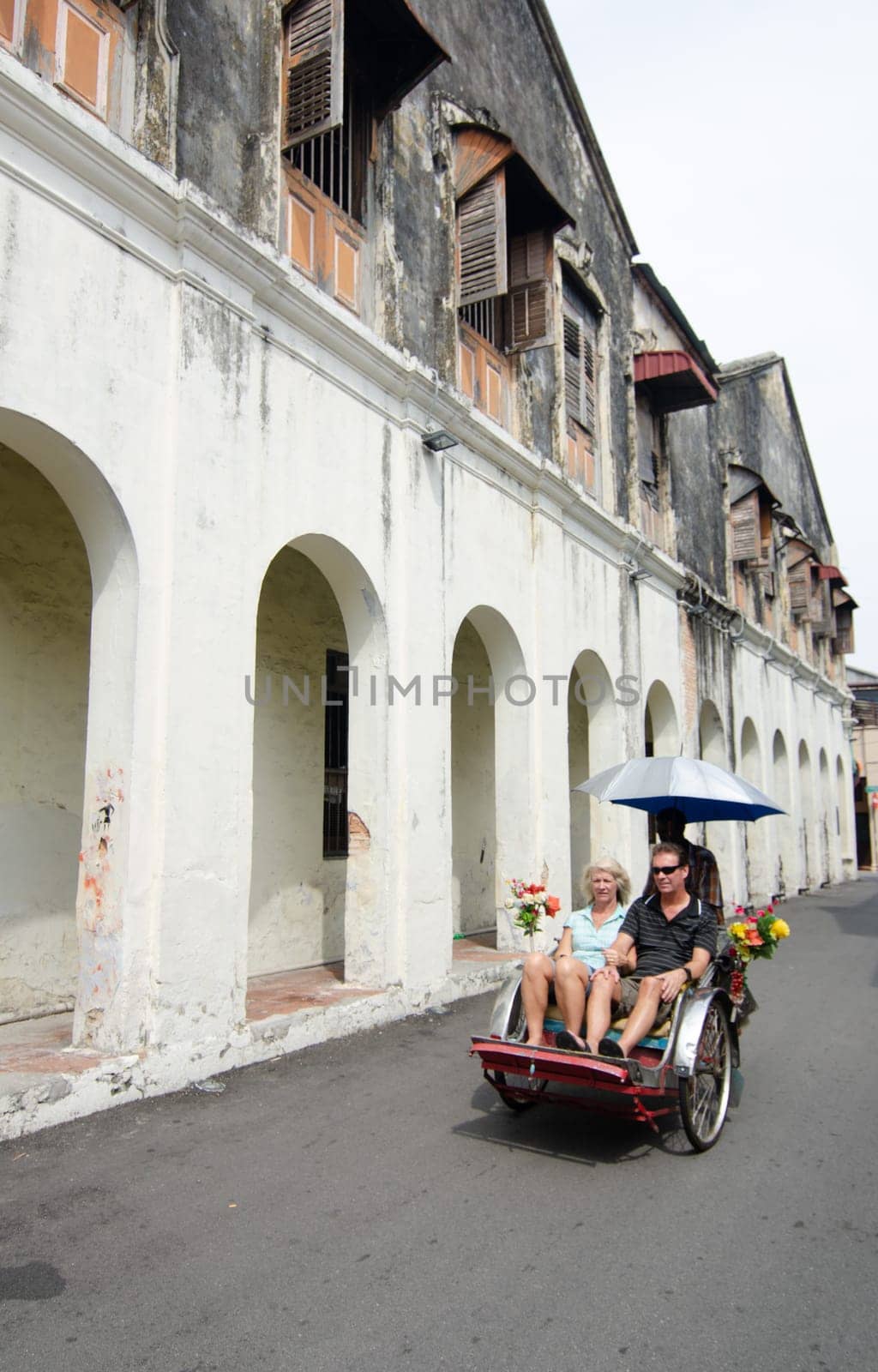 Georgetown, Penang/Malaysia - Aug 07 2016: Trishaw with passengers visit the heritage house at Georgetown.