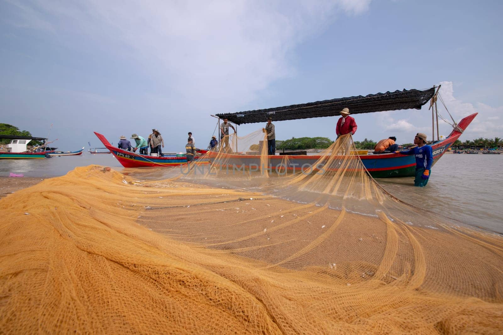 Kuala Muda, Penang/Malaysia - Mar 19 2017: Fishermen repair fishing net.
