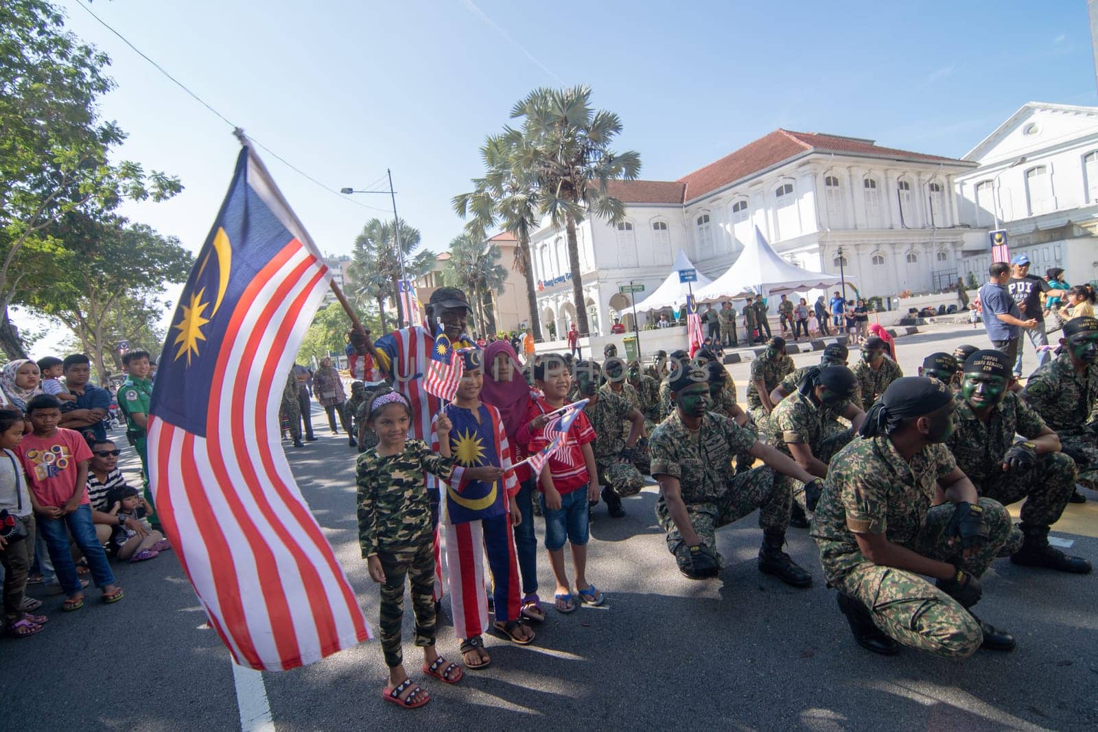 George Town, Penang/Malaysia - Aug 31 2017: Patriotic Malaysia wave Malaysia flag beside soldier.
