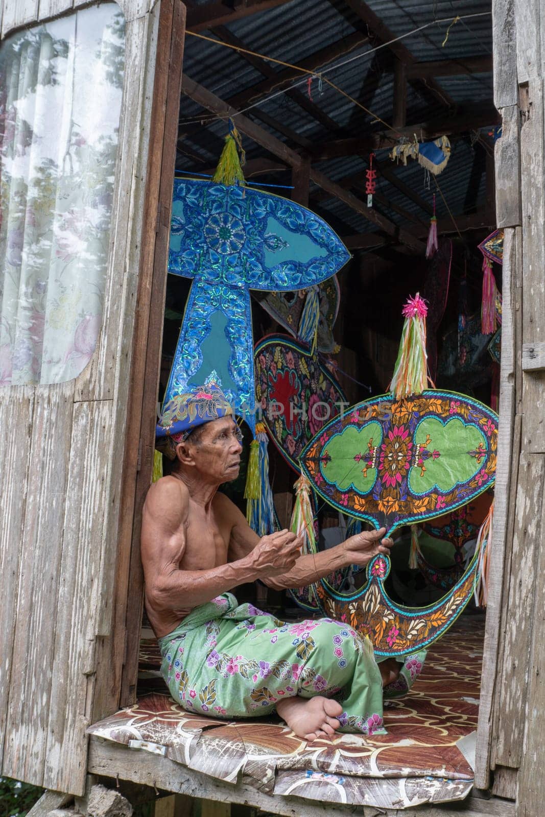 Kota Bahru, Kelantan/Malaysia - Jul 15 2017: A man sit and hold wau.