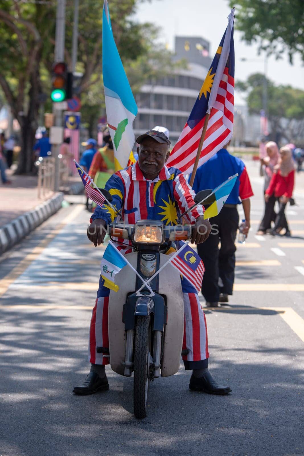 George Town, Penang/Malaysia - Aug 31 2017: A man with malaysia flag, costume, motor at street.